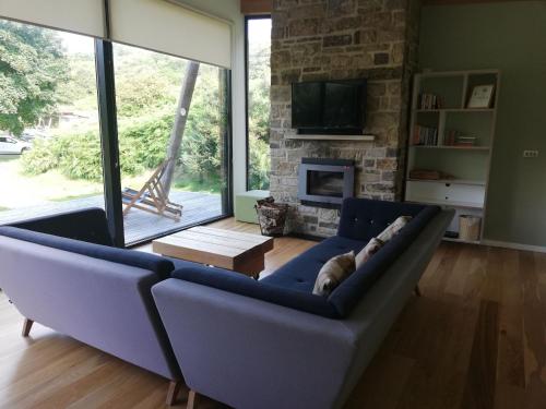a blue couch in a living room with a fireplace at Yorkshire Dales Lodge 1 by Together Travel - 3-Bed Ensuite Retreat in Richmond