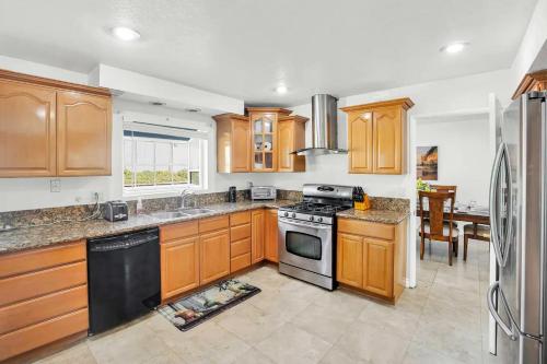 a kitchen with wooden cabinets and a stove top oven at Large Family Home - Only 20 mins from Disneyland in Fullerton