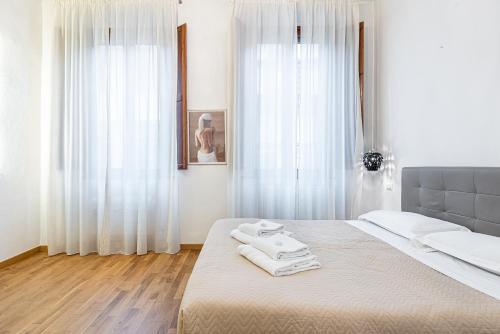 een slaapkamer met een bed met twee handdoeken erop bij Emanuele's house in Florence