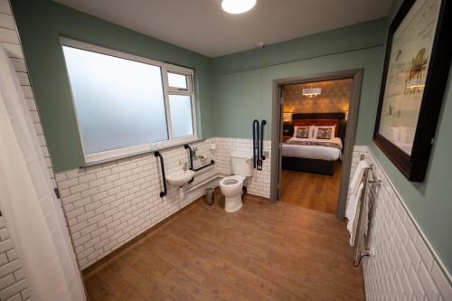 a bathroom with a toilet and a bed in a room at Riverside Hotel by Chef & Brewer Collection in Burton upon Trent