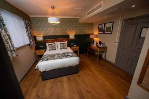 a hotel room with a bed and a desk at Riverside Hotel by Chef & Brewer Collection in Burton upon Trent