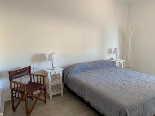 1 dormitorio con cama, silla y escritorio en Casa QUEQUEN CHICO en Quequén