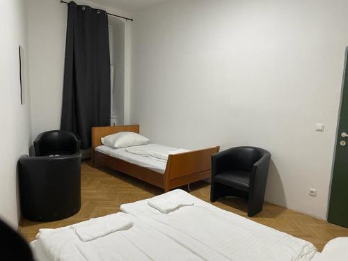 um quarto com duas camas e duas cadeiras em easybook-in em Viena