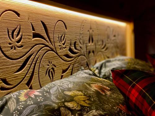a wooden headboard with writing on it next to pillows at Domek Góralski na Ubocy z jacuzzi in Białka Tatrzanska