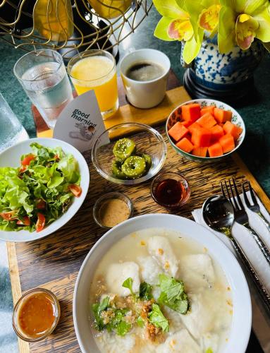 a table with a bowl of soup and bowls of vegetables at neil niwas in Bangkok