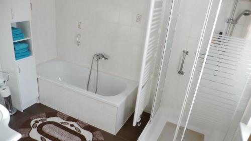 biała łazienka z wanną i toaletą w obiekcie Ferienhaus im Grünen w mieście Harztor