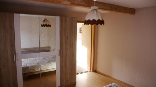 1 dormitorio con una puerta de cristal que conduce a una cama en Ferienhaus im Grünen, en Harztor