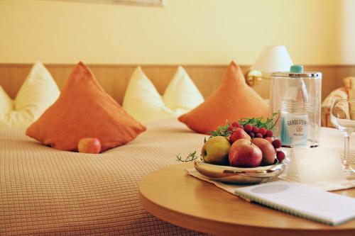 a bowl of fruit on a bed with pillows at May-Hof in Leverkusen
