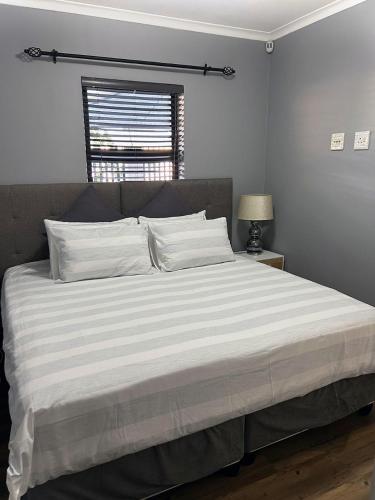 1 cama grande en un dormitorio con ventana en 81 on Groenewoud en Ciudad del Cabo
