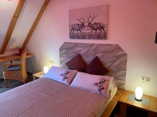 ein Schlafzimmer mit einem Bett und einem Gemälde von Hirschen an der Wand in der Unterkunft Gipfel Lounge in Hahnenklee-Bockswiese