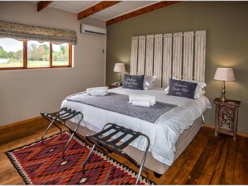 a bedroom with a large bed and a window at Sevens Guesthouse in Kroonstad