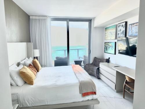 Schlafzimmer mit einem Bett, einem Schreibtisch und einem Fenster in der Unterkunft Hyde Resort Oceanview Luxurious 2-Bedroom PH 6Pax in Hollywood