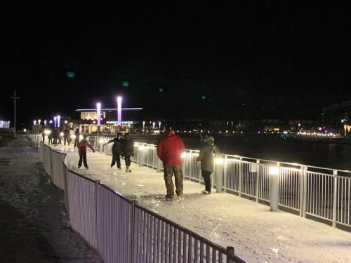 a group of people walking on a bridge at night at PET FRIENDLY CONDOS at FRIDAY HARBOUR in Innisfil