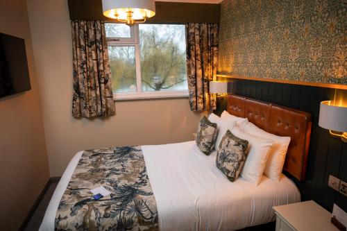 a bedroom with a bed with pillows and a window at Riverside Hotel by Chef & Brewer Collection in Burton upon Trent