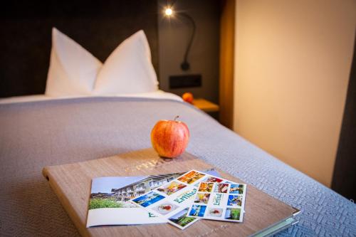 an apple sitting on top of a bed with a book at Familiengut Ertlhof in Seeboden