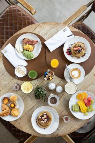 a wooden table with plates of food on it at Sublime Comporta Country Retreat & SPA in Comporta