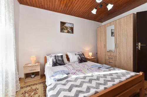 sypialnia z dużym łóżkiem i drewnianym sufitem w obiekcie House Smoljanci 1009 w mieście Smoljanci