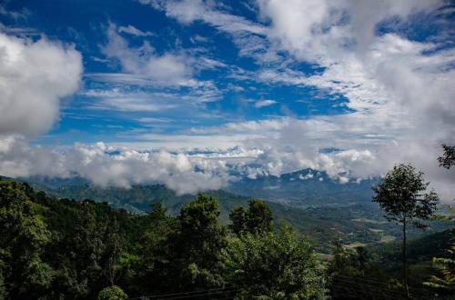 a view of the mountains with clouds in the sky at Hasera Organic Farmstay: Farm to Table & Mountain View in Dhulikhel