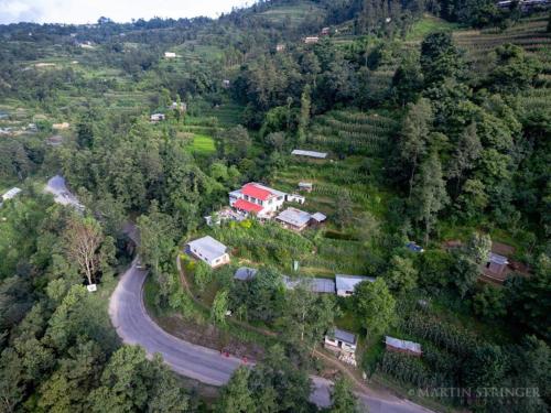 an aerial view of a house on a hill with a road at Hasera Organic Farmstay: Farm to Table & Mountain View in Dhulikhel