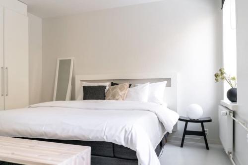 biała sypialnia z dużym łóżkiem i stołem w obiekcie Spacious 1 BR with a central location w Helsinkach