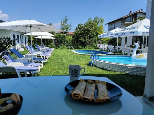 um prato de pão numa mesa ao lado de uma piscina em Weißer Schwan Белият лебед em Shkorpilovtsi