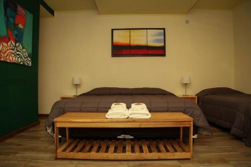 Un dormitorio con una cama y una mesa con zapatos. en Hostería Jasy en Colonia Carlos Pellegrini