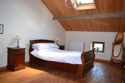 1 dormitorio con 1 cama grande y techo de madera en Two Hoots - farmhouse with summer pool., en Châteauponsac