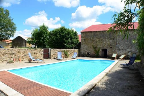 una piscina en un patio con sillas y un edificio en Two Hoots - farmhouse with summer pool., en Châteauponsac