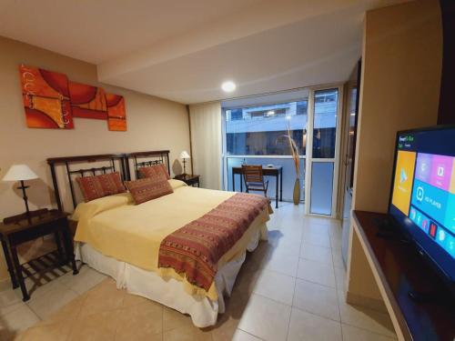 1 dormitorio con 1 cama y TV de pantalla plana en Departamento Caseros Salta en Salta