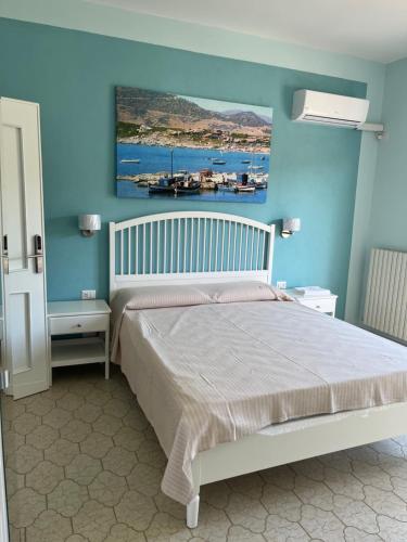 1 dormitorio con 1 cama con una pintura en la pared en Casa Tacconi, en Villasimius