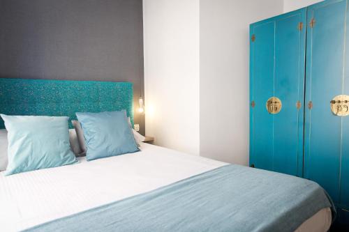 a bedroom with a large bed with a blue headboard at Apartments Holidays2Malaga City Center in Málaga