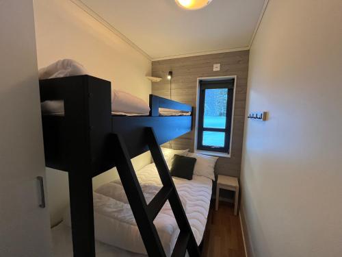 a small room with two bunk beds and a window at Funäs Fjällby Funäsdalen in Funäsdalen