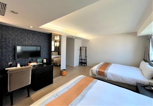 Habitación de hotel con 2 camas y TV de pantalla plana. en Ren Mei Fashion Hotel en Taichung