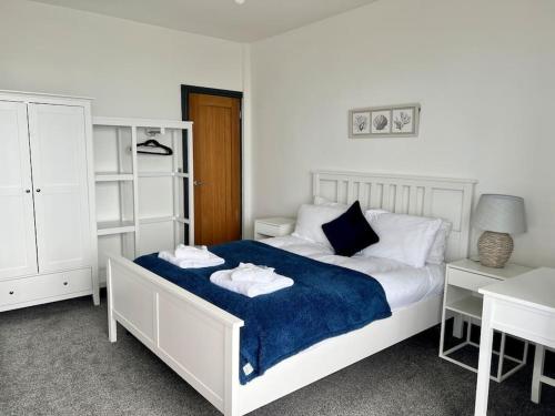 a bedroom with a bed with two towels on it at The Seafront Apartment - Westbrook Bay Beach - By Goldex Coastal Breaks in Kent