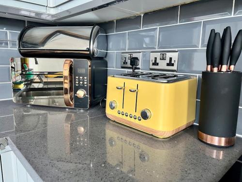 a kitchen counter with a yellow toaster and a toaster at The Seafront Apartment - Westbrook Bay Beach - By Goldex Coastal Breaks in Kent