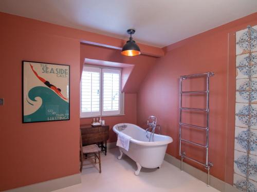 baño con bañera y un cartel en la pared en Red Cottage B&B en Rye