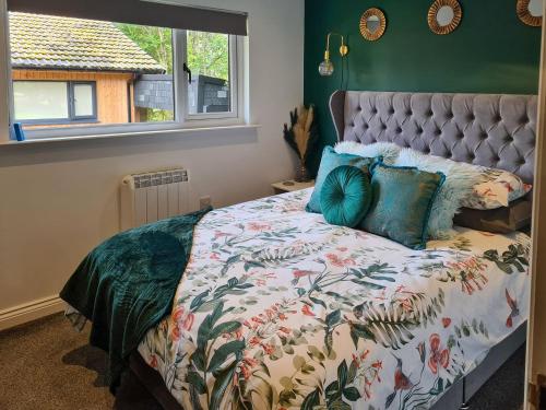 - une chambre avec un lit doté d'un couvre-lit floral et d'une fenêtre dans l'établissement The Hideaway, à Otterburn