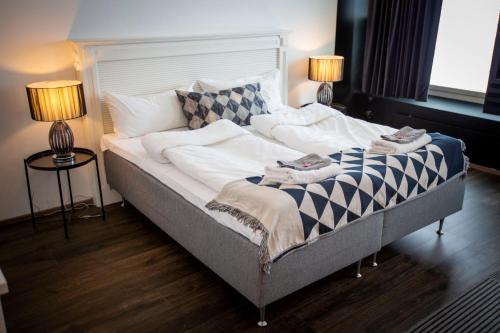 a bedroom with a bed with two lamps on it at Hotelli Olof in Tornio