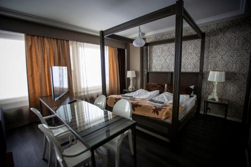a hotel room with a bed and a glass table at Hotelli Olof in Tornio