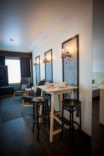 a room with a table and chairs and a bed at Hotelli Olof in Tornio