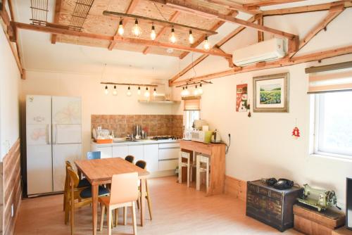 a kitchen with a table and a kitchen with a refrigerator at Mareka Pension in Jeju