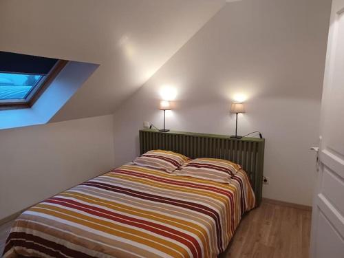 - une chambre avec un lit et deux lampes au-dessus dans l'établissement Le Duplex Saint Pry, à Béthune