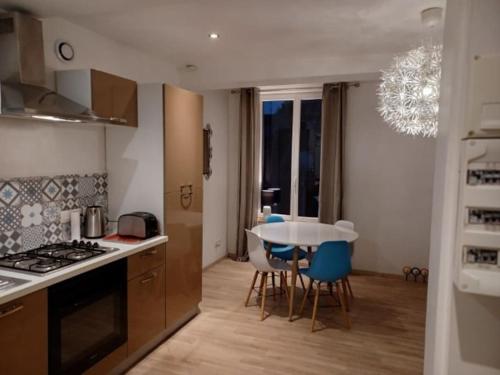 une cuisine avec une table et des chaises ainsi qu'une salle à manger dans l'établissement Le Duplex Saint Pry, à Béthune