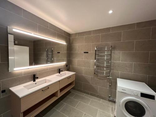 a bathroom with a sink and a washing machine at Kåvan Townhouse Funäsdalen in Funäsdalen