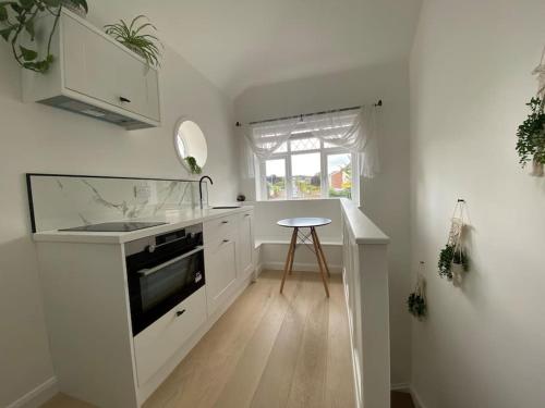 a white kitchen with a sink and a stove at The Annex, Bath Road, Saltford in Saltford