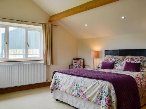 a bedroom with a large bed and a window at Farm Cottage in Cleator