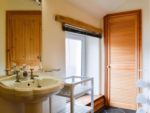a bathroom with a sink and a mirror at Farm Cottage in Cleator