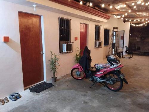 a motorcycle parked in front of a house at Jan's Pension House - Sibulan National Highway in Sibulan