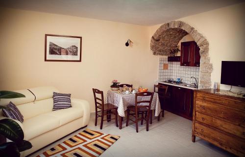 een woonkamer met een bank en een tafel met stoelen bij La Costa Del Sole in San Fele