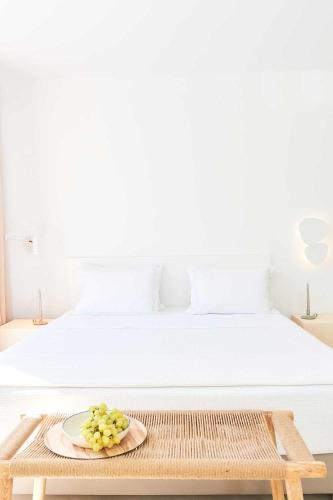 a table with a plate of grapes on top of a bed at Cavo Delea Villas & Suites in Possidi